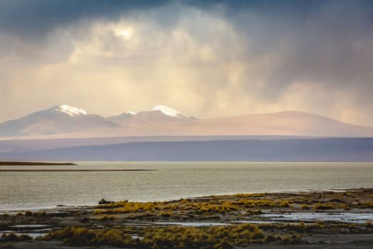 Salt lake reflection and idyllic volcanic landscape at Sunset, Atacama desert, Chile border with Bolivia