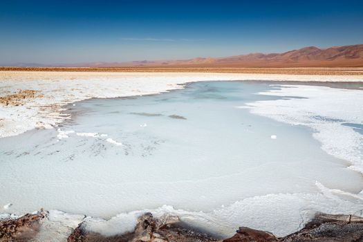 Salt lake reflection and idyllic volcanic landscape at sunrise, Atacama desert, Chile border with Bolivia