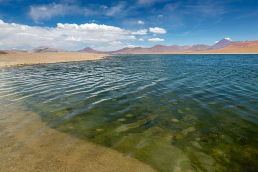 Salt lake reflection and idyllic volcanic landscape at sunrise, Atacama desert, Chile border with Bolivia