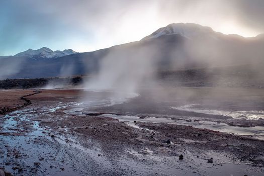 Geysers El Tatio with river and Peaceful dramatic volcanic landscape at sunrise, Atacama Desert, Chile