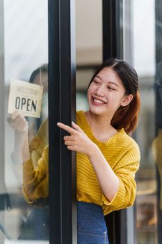 Beautiful female manager in restaurant with tablet. Woman coffee shop owner with open sign. Small business concept.