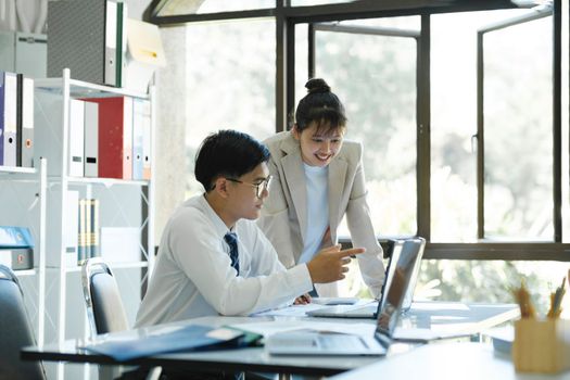 Businesspeople or colleagues are working together on investment project, discussing, sharing ideas, planning, and analyzing the business strategy and finance using laptop computer.