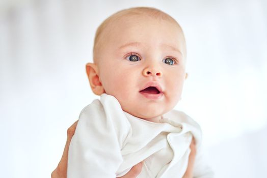 The world looks amazing from up here. a baby boy being held by his parent at home