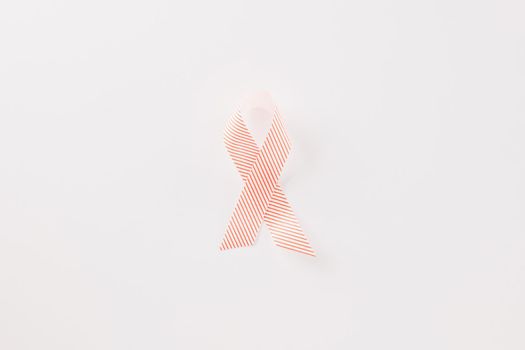 Close up pink awareness ribbon of International World Cancer Day campaign isolated on white background with copy space, concept of medical and health care support, 4 February