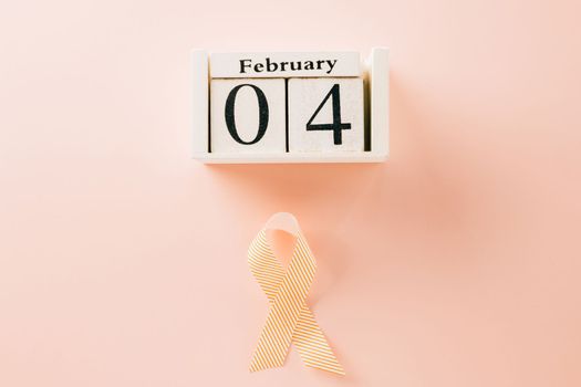 Pink awareness ribbon sign and Calender 4 February of World Cancer Day campaign on pastel pink background with copy space, concept of medical and health care support