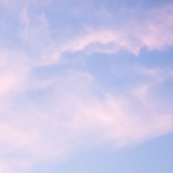 Blue sky background with white and pink clouds at sunset. High quality photo