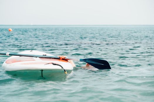 Sea woman sup. Silhouette of happy young woman in pink bikini, surfing on SUP board, confident paddling through water surface. Idyllic sunset. Active lifestyle at sea or river. Slow motion