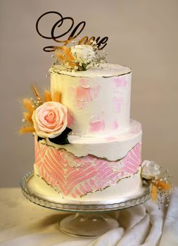 wedding bunk cake decorated with fresh flowers on a dark background