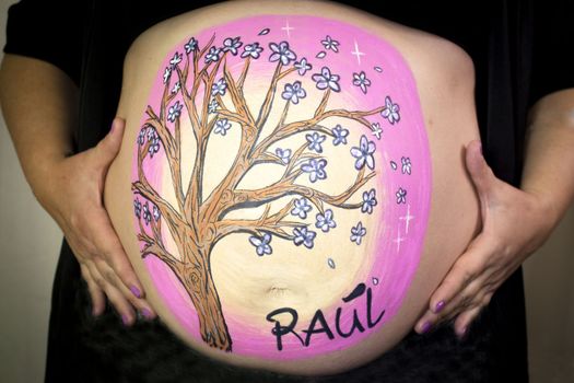 Girl drawing on belly of pregnant woman. No copy space
