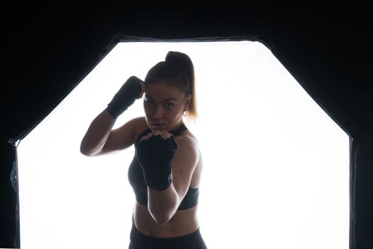 Woman Boxer In Gloves Training On a black, red, yellow Background