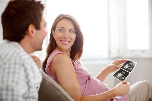 Thats our baby. Young couple looking at a image of their babies sonogram