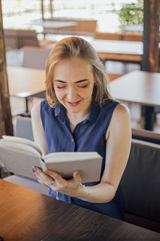 Beautiful woman with short hair sitting at the terrace on a sunny day working from home using laptop