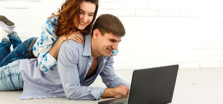 Couple buying online together with a laptop on a desktop at home