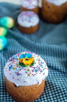 Delicious Easter food, stylish easter eggs, beets, cheese, butter, ham, homemade Easter bread and wicker basket with blooming spring flowers on rustic table, orthodox traditions. Happy Easter.