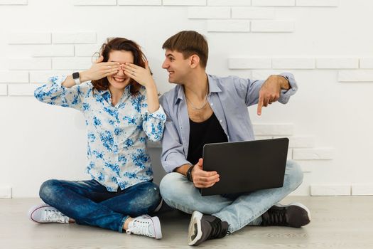 Portrait of happy young couple using laptop isolated