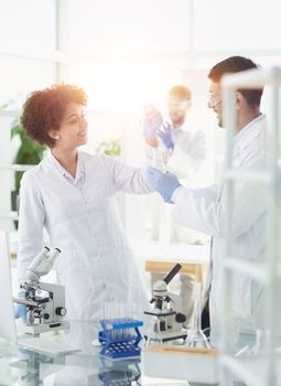 Team of Scientists Working Using Microscope, Analysing Microbiology Samples