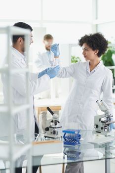 Team of Scientists Working Using Microscope, Analysing Microbiology Samples