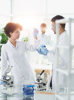 Team of Scientists Working Using Microscope, Analysing Microbiology Samples