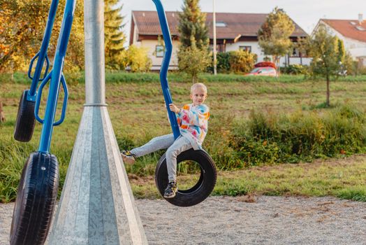 Funny cute happy baby playing on the playground. The emotion of happiness, fun, joy. Smile of a child. boy playing on the playground.