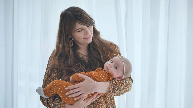 A loving mother and child at the window with curtains