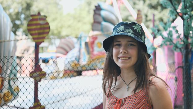 A girl looks at a working ride in a children's park