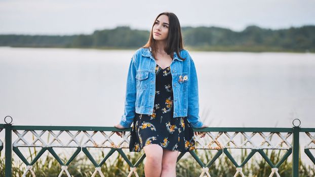Portrait of a lonely girl by a lake