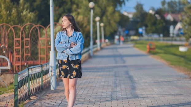 A lonely girl walks along the city's promenade