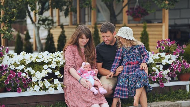 Portrait of a young family in a garden with young children