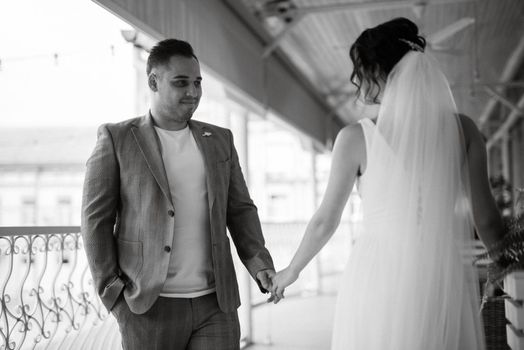 young couple the groom in a blue suit and the bride in a white dress on a walk