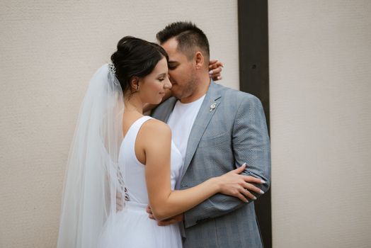 young couple the groom in a blue suit and the bride in a white dress on a walk