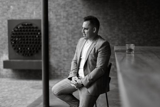 portrait of the groom in a light gray suit indoors