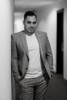 portrait of the groom in a light gray suit indoors