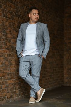 portrait of the groom in a light gray suit indoors