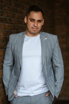 portrait of the groom in a light gray suit indoors