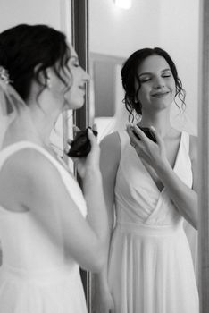 preparations for the bride with the dressing of the wedding dress in the studio