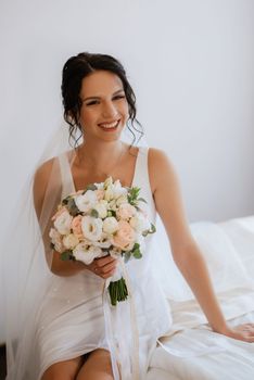 preparations for the bride with the dressing of the wedding dress in the studio