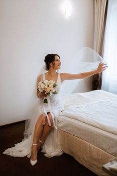 preparations for the bride with the dressing of the wedding dress in the studio