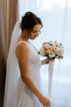 preparations for the bride with the dressing of the wedding dress in the studio