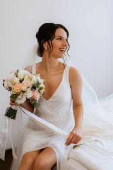 preparations for the bride with the dressing of the wedding dress in the studio