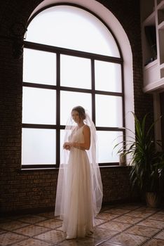 preparations for the bride with the dressing of the wedding dress in the studio