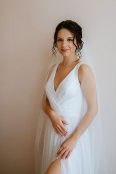 preparations for the bride with the dressing of the wedding dress in the studio