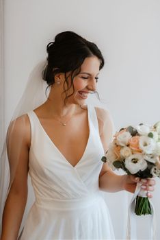 preparations for the bride with the dressing of the wedding dress in the studio