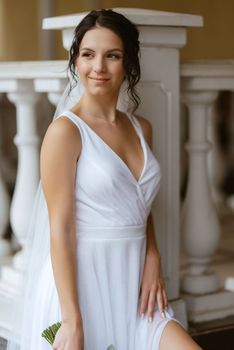 preparations for the bride with the dressing of the wedding dress in the studio