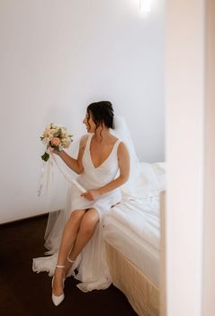 preparations for the bride with the dressing of the wedding dress in the studio