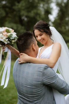 the first meeting of the bride and groom in wedding outfits in the park