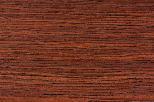 Rosewood texture. Texture of dark mahogany with an intense pattern, natural rosewood veneer for the production of furniture or yacht decoration.