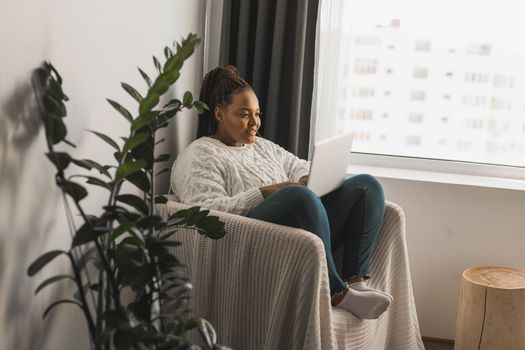 African american young woman using laptop on bed - technologies and communication and social network