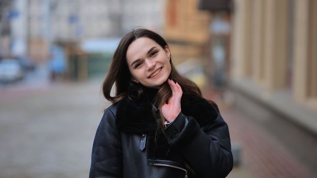 Portrait of a posing happy girl in the city in early spring