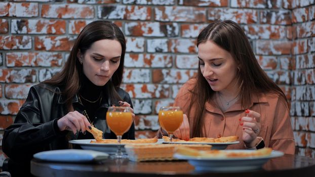 Young girls eat in a cafe and talk