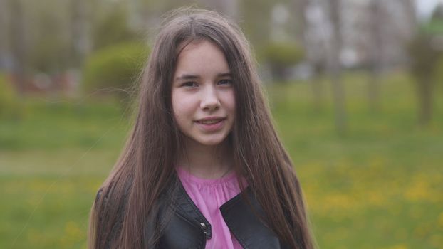 A teenage girl with long hair twirls and poses for the camera